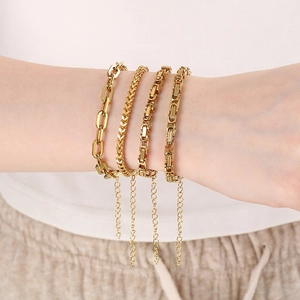 Close-up of four stacked 18K gold plated stainless steel layered chain bracelets for women