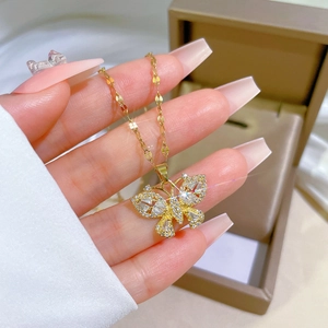 Macro shot of gold butterfly pendant with sparkling cubic zirconia on a delicate chain