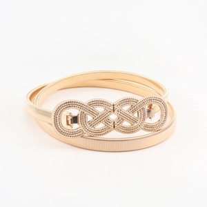 Detailed view of women's gold elastic metal waist belt with twisted infinity buckle