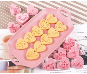 Macro view of 10 heart-shaped LOVE cookie cutters and textured fondant embossing tools