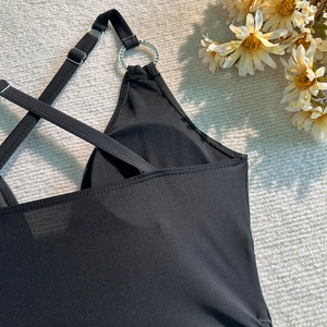 Détail d'un maillot de bain noir avec anneaux métalliques et bretelles réglables