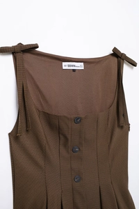 Detailed close-up of brown houndstooth dress with square neck and button front