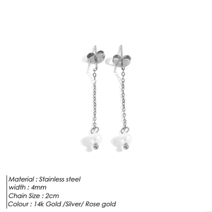 Macro shot of stainless steel chain earrings with white pearl pendants and silver finish