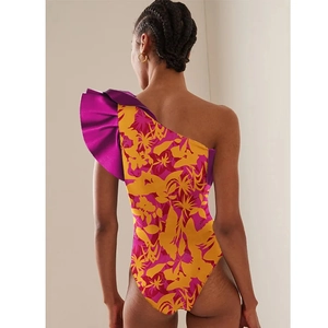 Detail of ruffle shoulder design and tropical floral print on a backless swimsuit