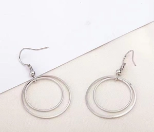 Detail view of double-layered silver metal hoop earrings on a clean background