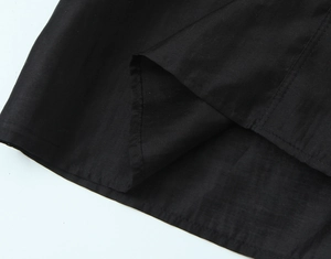 Detail shot of black casual shirt featuring durable double-stitched hem and fabric texture