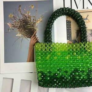 Detail of handmade beaded tote bag featuring green gradient acrylic beads with macro texture