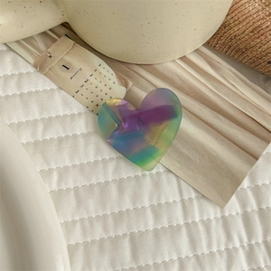 Detail of heart-shaped acetate hair clip with iridescent purple and green gradient finish