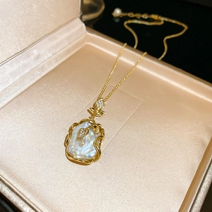 Détail du collier de perles baroques avec motif de feuilles dorées en coffret