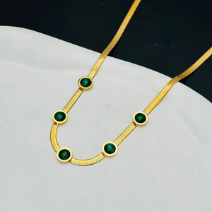 Golden flat snake chain necklace featuring five circular emerald green gemstones