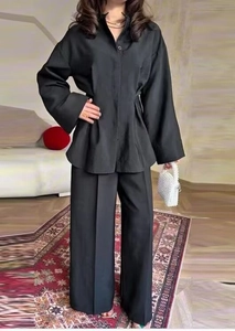 Front view of black two-piece lounge set with long-sleeved shirt and wide-leg trousers