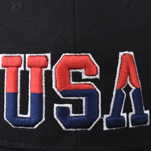 Macro detail of high-quality red and blue USA 3D embroidery on black cotton baseball cap