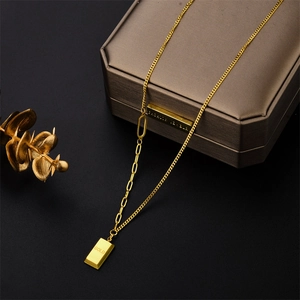 Golden titanium steel necklace with gold bar pendant on a minimalist black background