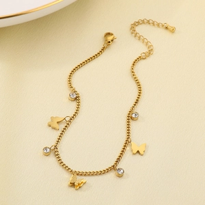 Double-layered gold anklet with butterfly charms and cubic zirconia on soft fabric