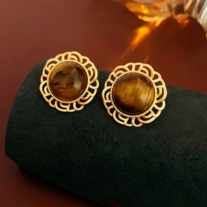 Close-up of vintage gold earrings with brown stone insets and hollow petal frames