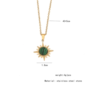 Detailed view of a gold stainless steel sun pendant with green stone and size specs