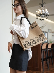 Macro shot of large jute tote bag with ethnic geometric pattern and woven handles