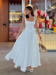 Close-up of elegant white sleeveless square-neck maxi dress with slim-fit waist and A-line hem