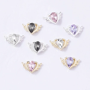 Detailed macro view of heart-shaped alloy nail charms with colorful teardrop crystals