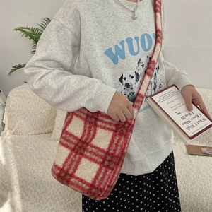 Detail of red and white checkered plush shoulder bag on casual autumn fashion outfit