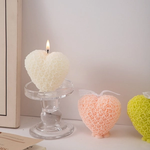 Detailed view of heart-shaped rose embossed scented candles on an elegant glass stand