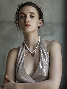 Détail d'un pendentif trèfle en or 18K sur un collier en corde tressée blanche