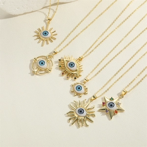 Detailed view of gold evil eye pendants featuring sun, moon and star charms with blue zircons