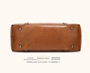 Detailed bottom view of brown leather bucket bag with four protective metal studs