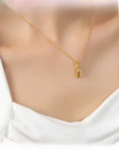 Gros plan du collier fer à cheval avec diamants pavés sur chaîne dorée porté au cou