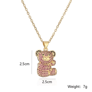 Detailed view of a gold plated bear pendant with purple and black cubic zirconia crystals
