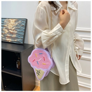 Detail of cute pink glitter ice cream cone crossbody bag with gold chain strap on model
