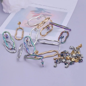 Flat lay of wavy stainless steel hoop earrings in gold, silver and rainbow colors