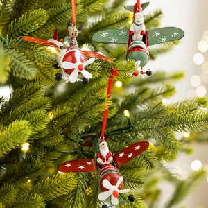 Three metal Christmas airplane ornaments with Santa, Reindeer and Snowman on a tree