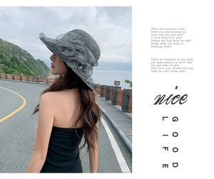 Detail of grey wide brim sun hat featuring stylish floral decor and wavy edges