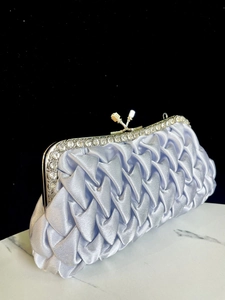 Silver pleated silk evening clutch detail, rhinestone frame and clasp for party dress.