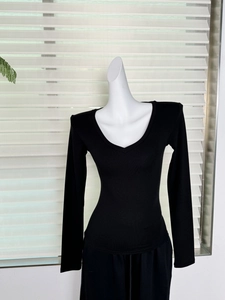 Détail du t-shirt moulant noir col en V à manches longues en modal sur un mannequin