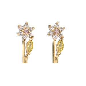 Detailed view of floral stud earrings with white petals and pink center stone
