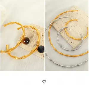 Detailed view of golden and silver bamboo style neck collars and bracelets with bead accents