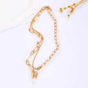 Detail of multi-layer gold necklace featuring white pearls and heart-shaped T-bar toggle clasp