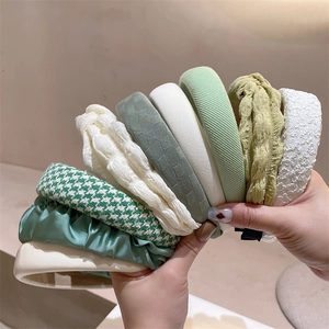 Green and cream padded fabric headbands with stripe and houndstooth texture