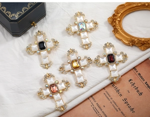 Detailed close-up of gothic cross brooches with rhinestones and colorful gemstone centers