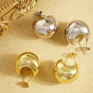 Polished hollow moon C-shape hoop earrings in gold and silver finish on a textured base