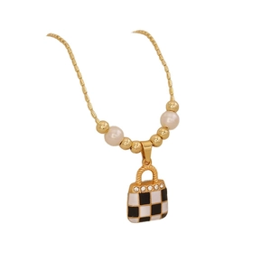 Gold necklace with checkered handbag pendant and pearls on white background