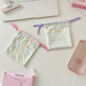 Detail of printed drawstring storage bags with cute cat pattern and checkered fabric design