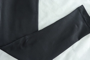 Close-up of smooth black high-density fabric texture and cuff detail on yoga set