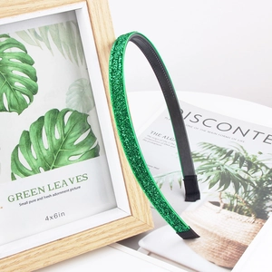 Detail view of sparkly green glitter headband with anti-slip teeth and black protective tips