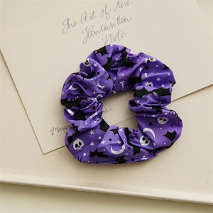 Détail macro du chouchou violet d'Halloween avec motifs de crânes, chauves-souris et étoiles