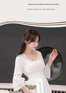Detailed side view of white V-neck lace dress with hollow embroidery and flared sleeves