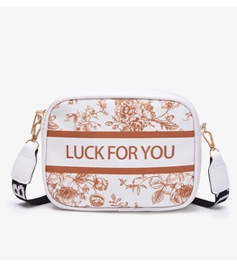 Detail of floral camera bag with LUCK FOR YOU print and wide crossbody strap