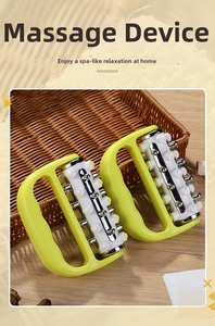 Detail of handheld massager with five rows of rollers and silver massage nodes